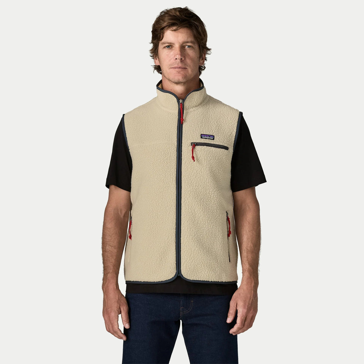 Gilet Retro Pile Pelican Patagonia porté de face, col montant bordé de marine et poche poitrine zippée à tirette rouge