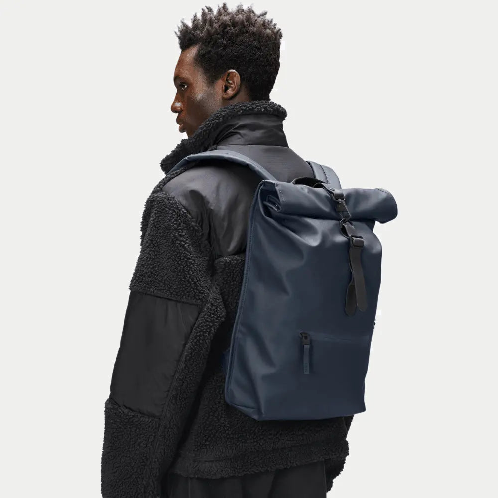 Rolltop Rucksack Bleu Marine porté sur le dos, volume compact et boucle de fermeture noire