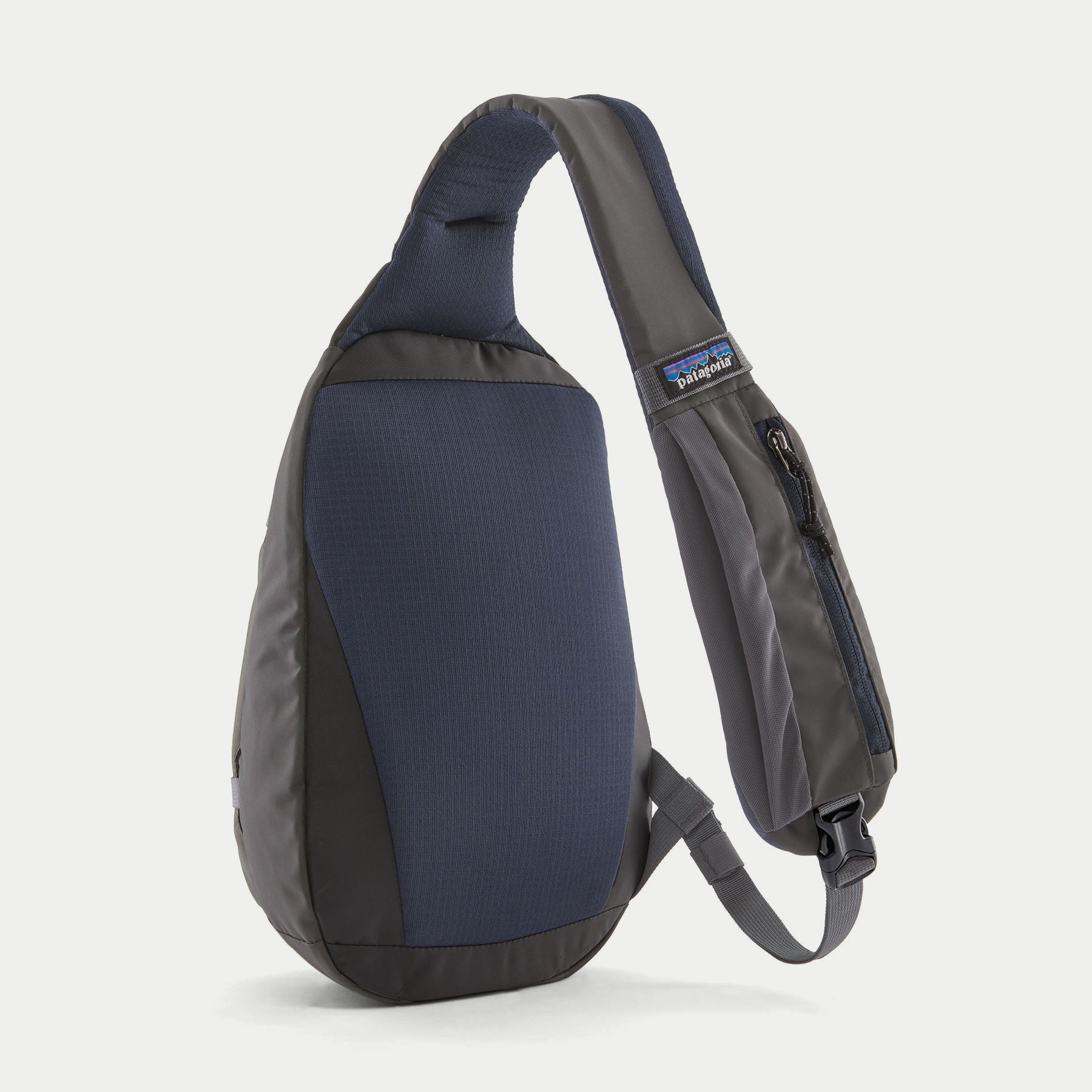Atom Sling 8L Smolder Blue Patagonia de dos : panneau ripstop bleu marine, bretelle rembourrée et poche zippée sur la sangle