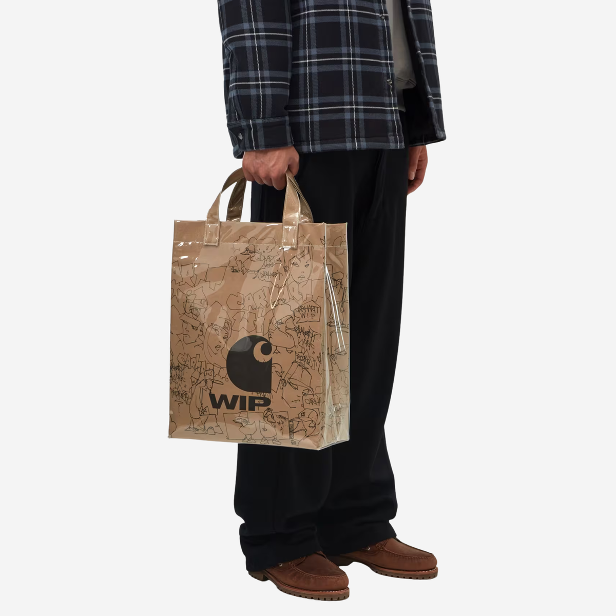 Sac en papier Blinkerfluid Carhartt WIP porté à la main, anses courtes et imprimé allover au trait noir