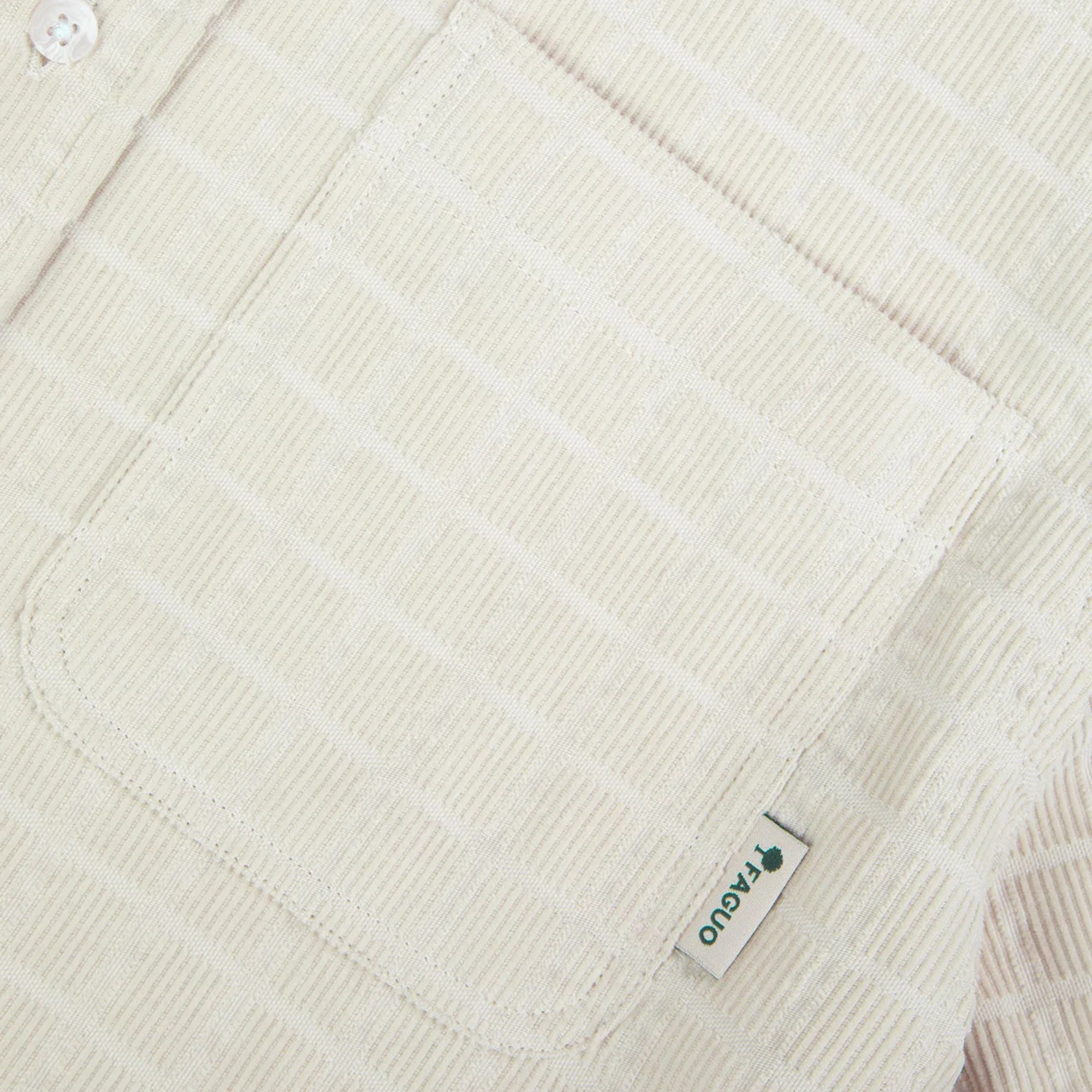 Détail du velours gaufré de la chemise Signy Faguo beige écru : côtes fines, poche poitrine et étiquette tissée