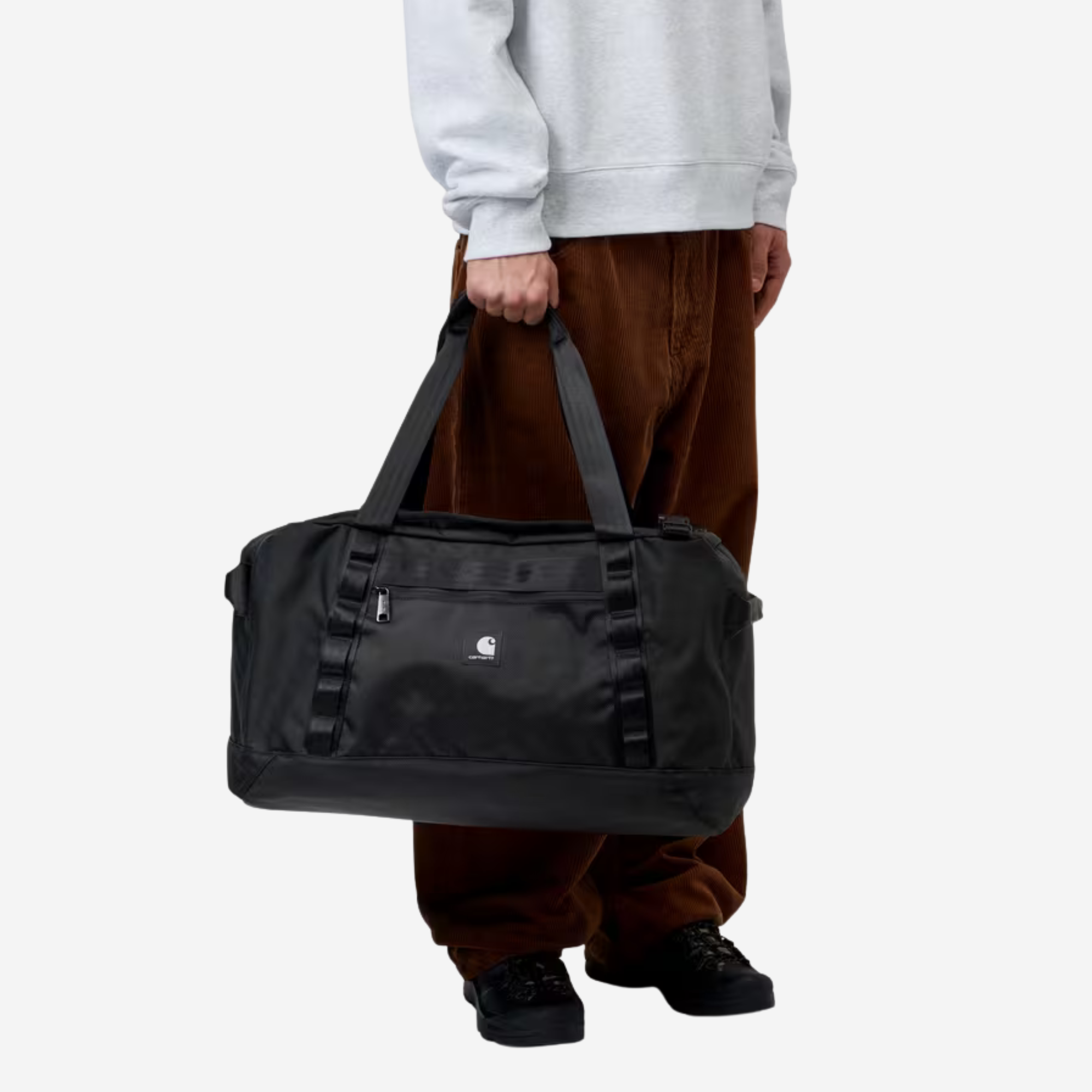 Petit sac de voyage Richmond noir Carhartt WIP porté à la main par ses deux poignées