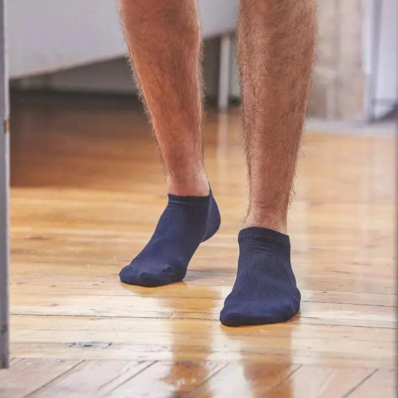 Socquettes bleu marine portées de dos sur un parquet clair, tige très basse