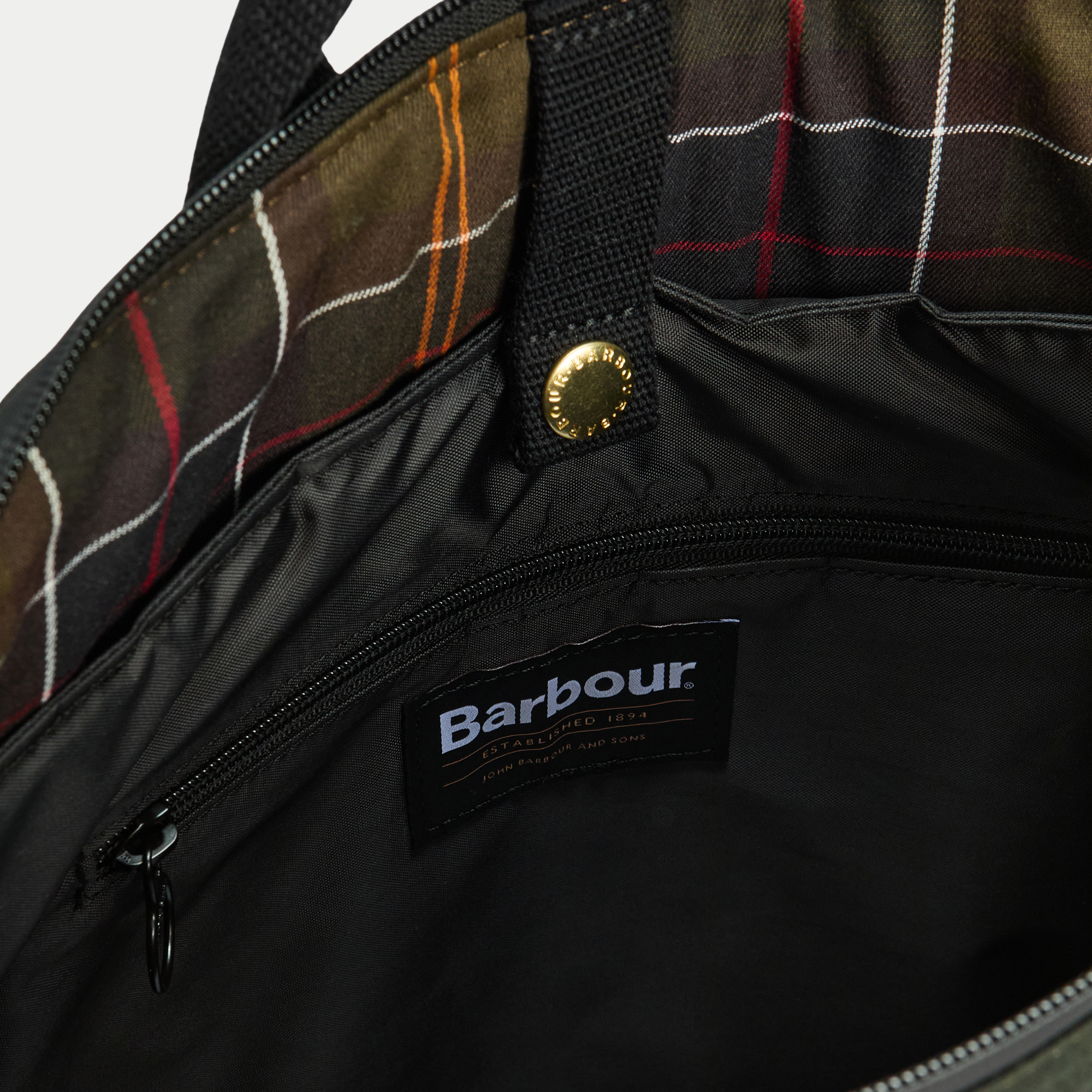 Intérieur du sac à dos Field Wax : doublure tartan Classic, poche zippée et compartiment ordinateur