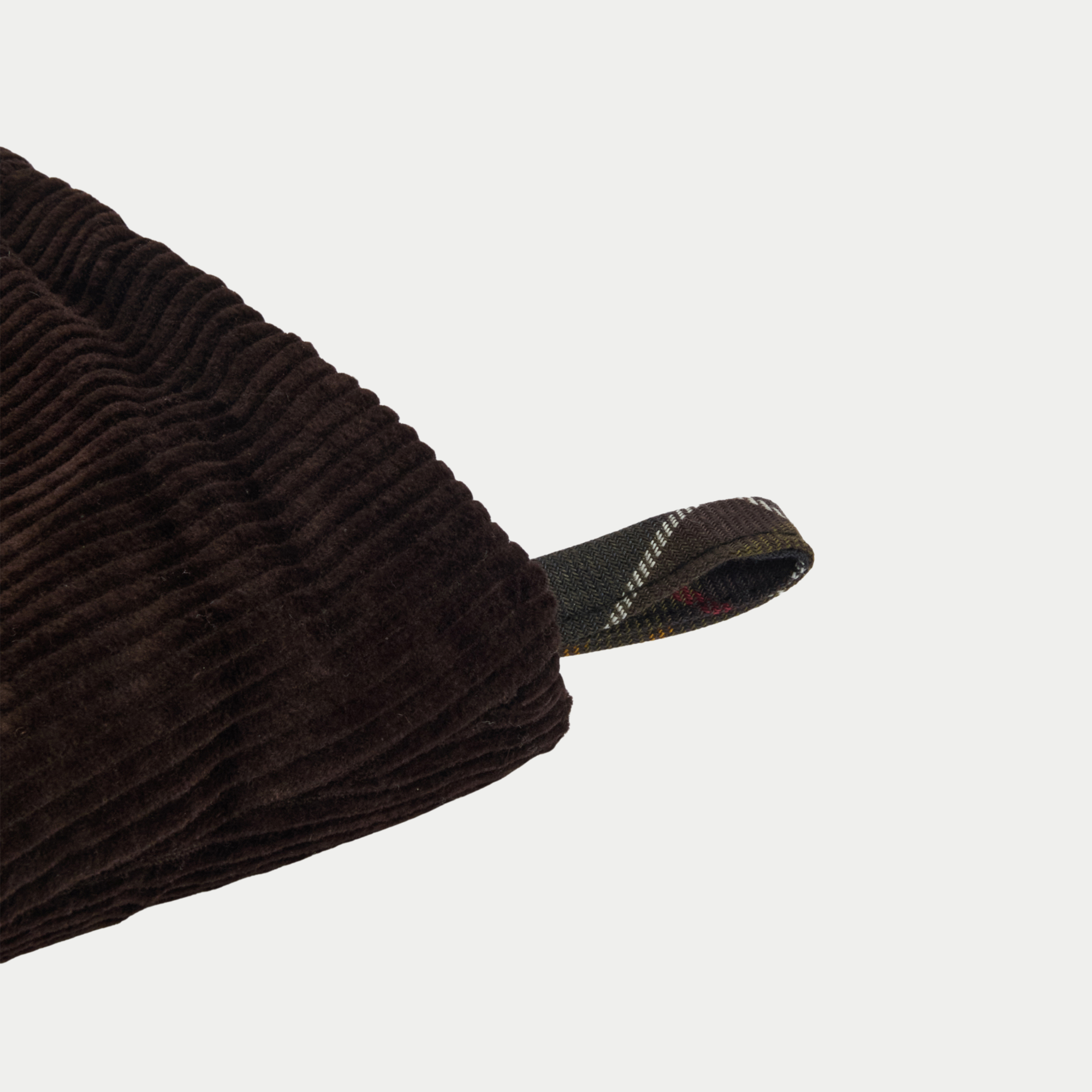 Gros plan de la boucle de suspension en tartan cousue sur le revers en velours côtelé brun de la chaussette de Noël Barbour