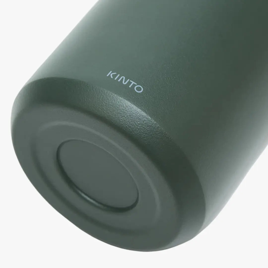 Macro du culot vert sauge mat du Strata Travel Tumbler, signature Kinto imprimée sur le fond