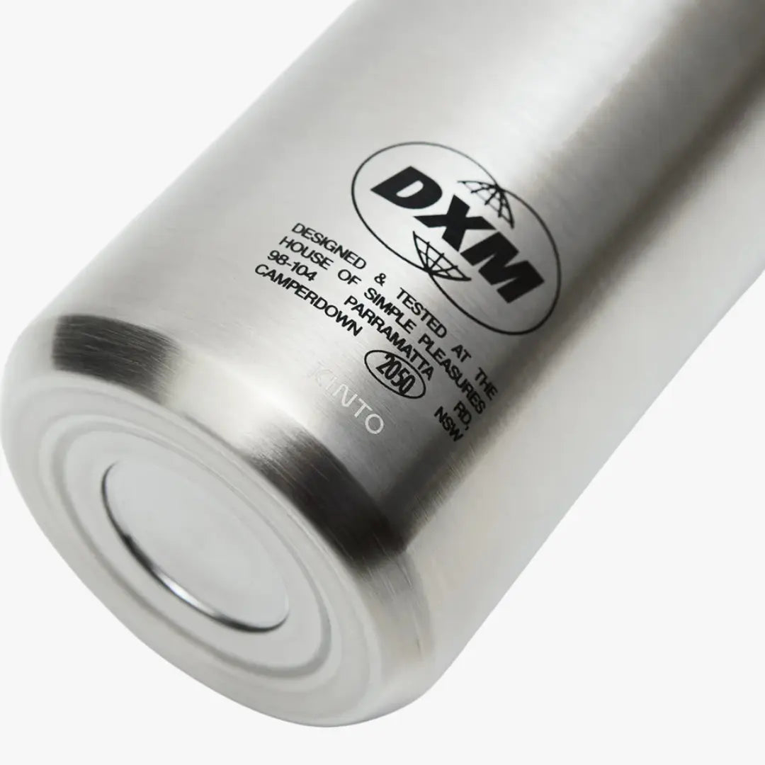 Culot inox brossé du Strata Travel Tumbler, logo DXM encerclé et signature Kinto au fond