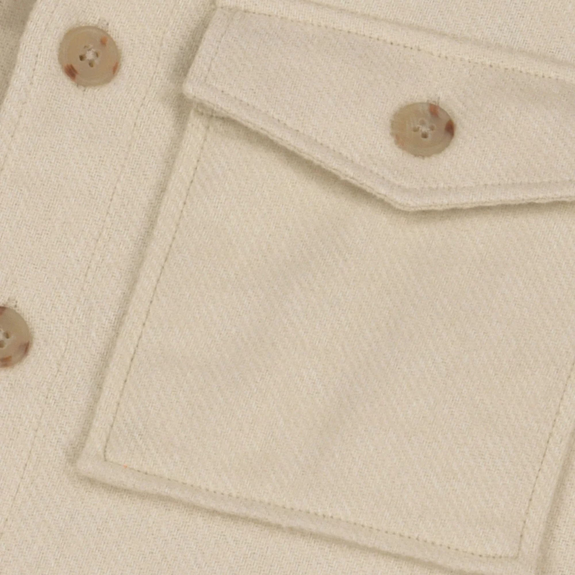 Détail du coton écru tissé sergé de la surchemise Flavigny Faguo, poche à rabat et bouton marbré