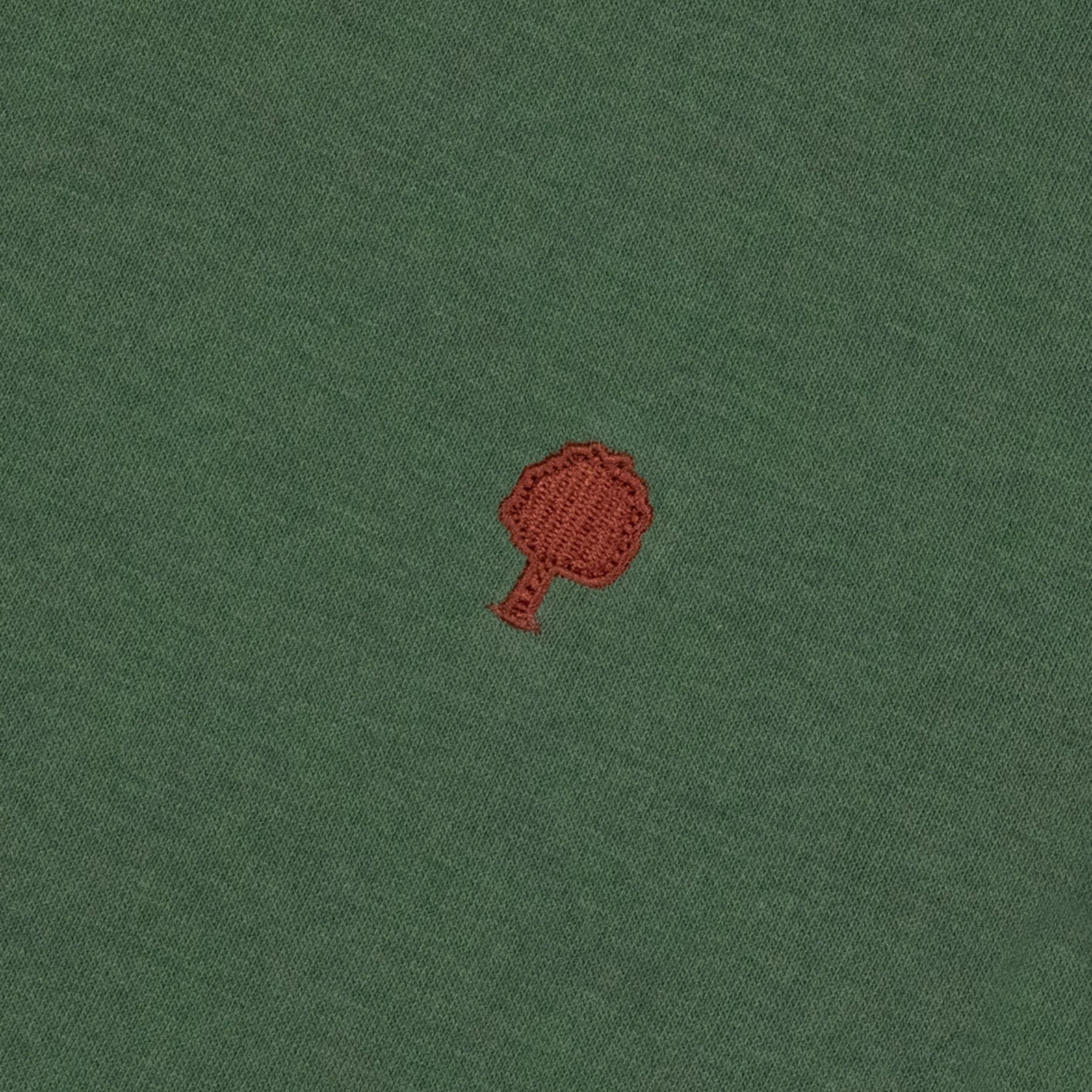Détail de la broderie arbre rouge brique sur le molleton vert forêt du sweat Donzy Faguo