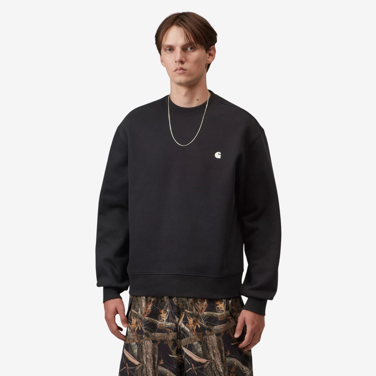 Sweat Mack Carhartt WIP noir porté de face, coupe balloon boxy sur un pantalon camo Carhartt