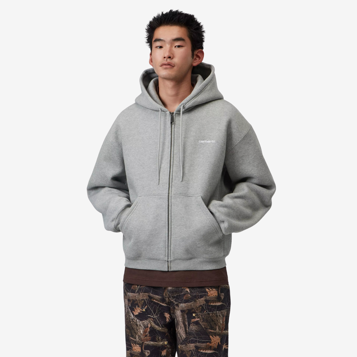 Sweat zippé Ebbert Grey Heather Carhartt WIP - porté de face, zip fermé et mains dans la poche kangourou