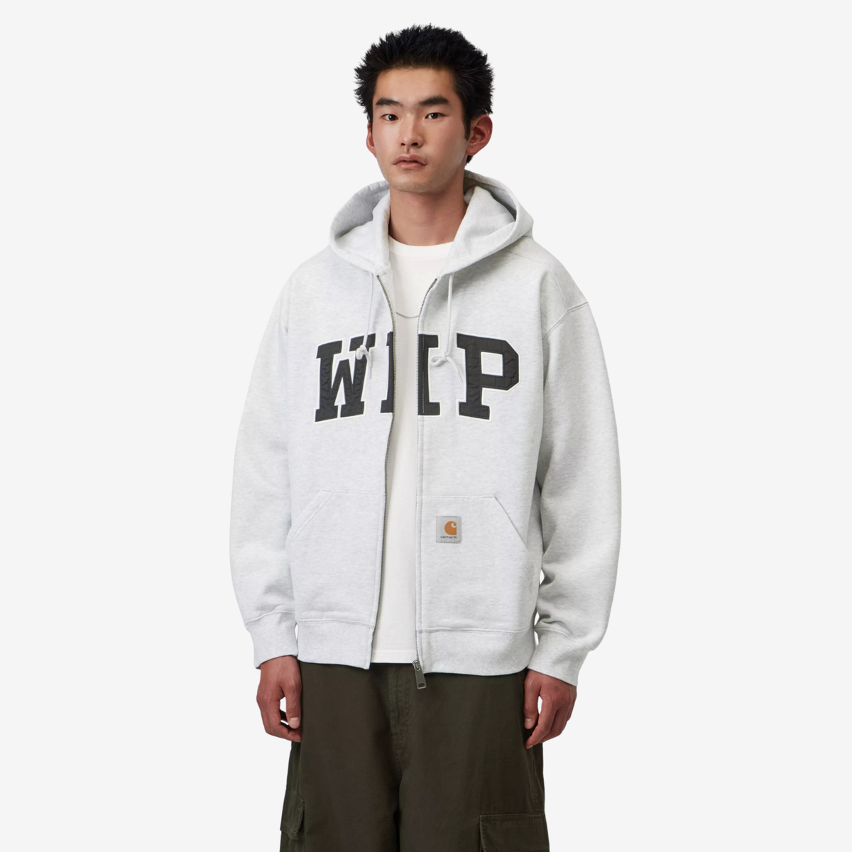 Sweat zippé Carhartt WIP Ash Heather porté ouvert sur un t-shirt blanc, capuche rabattue et poche kangourou