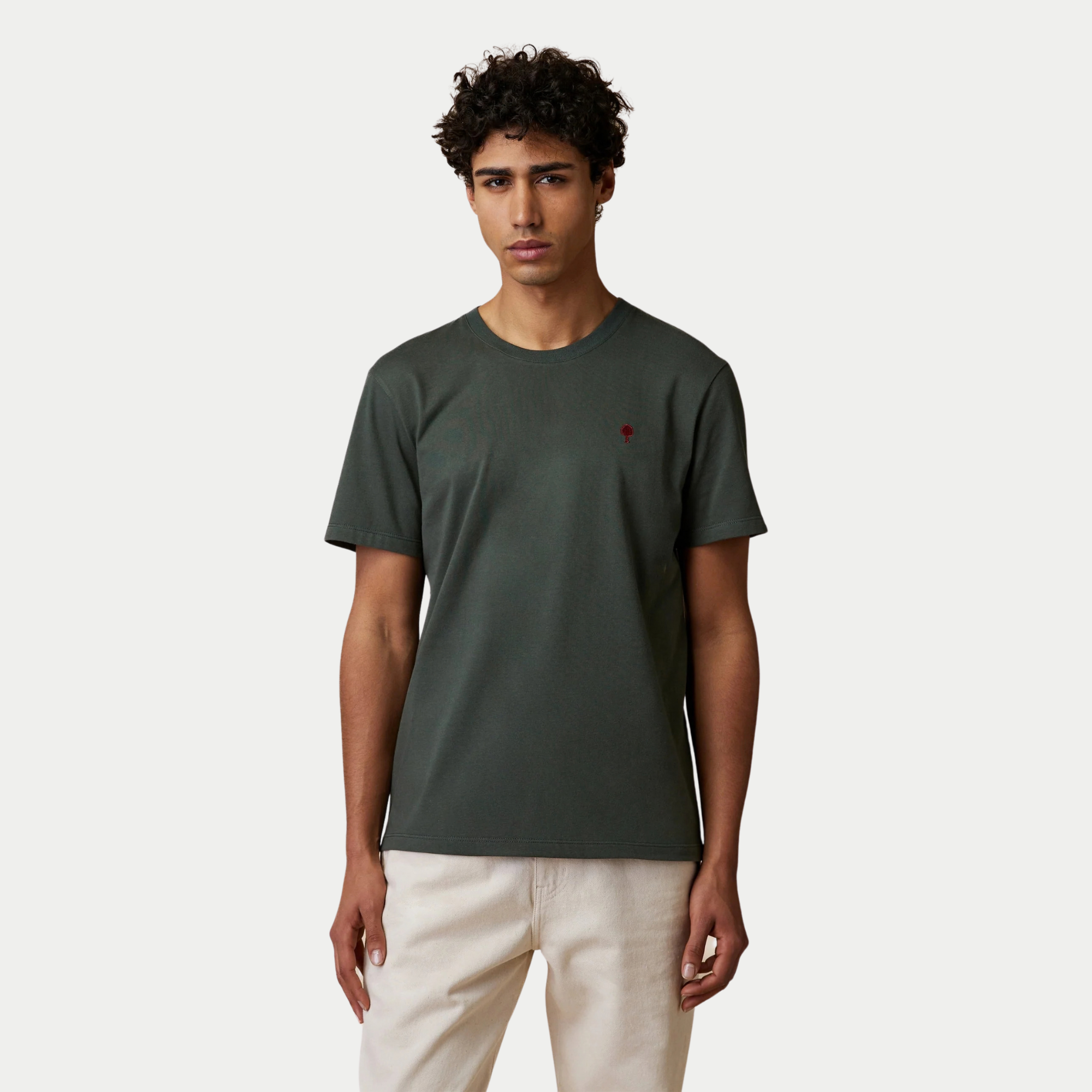 T-shirt Arcy Faguo vert foncé porté de face avec un pantalon écru, coupe droite