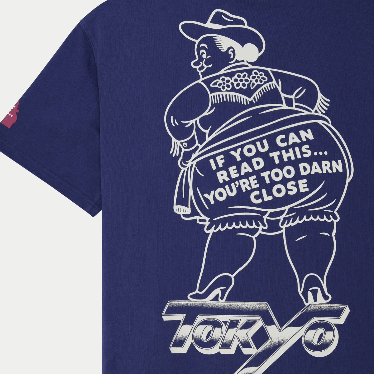 Macro de la sérigraphie dos du T-shirt Bloomers Deus Ex Machina : cow-girl à franges et inscription « You're too darn close »