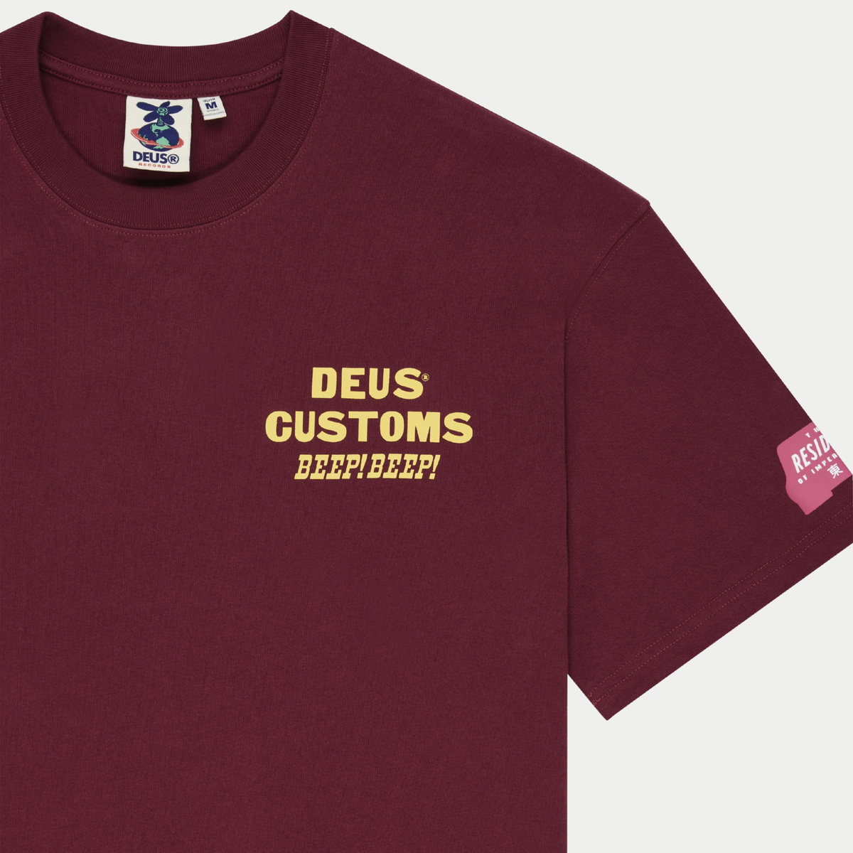 T-shirt Bloomers bordeaux Deus Ex Machina - détail de l’encolure côtelée, étiquette Deus Records et patch rose sur la manche