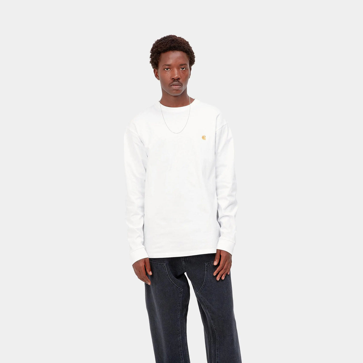 Homme portant le T-shirt manches longues Chase blanc Carhartt WIP avec un jean noir, vue de face