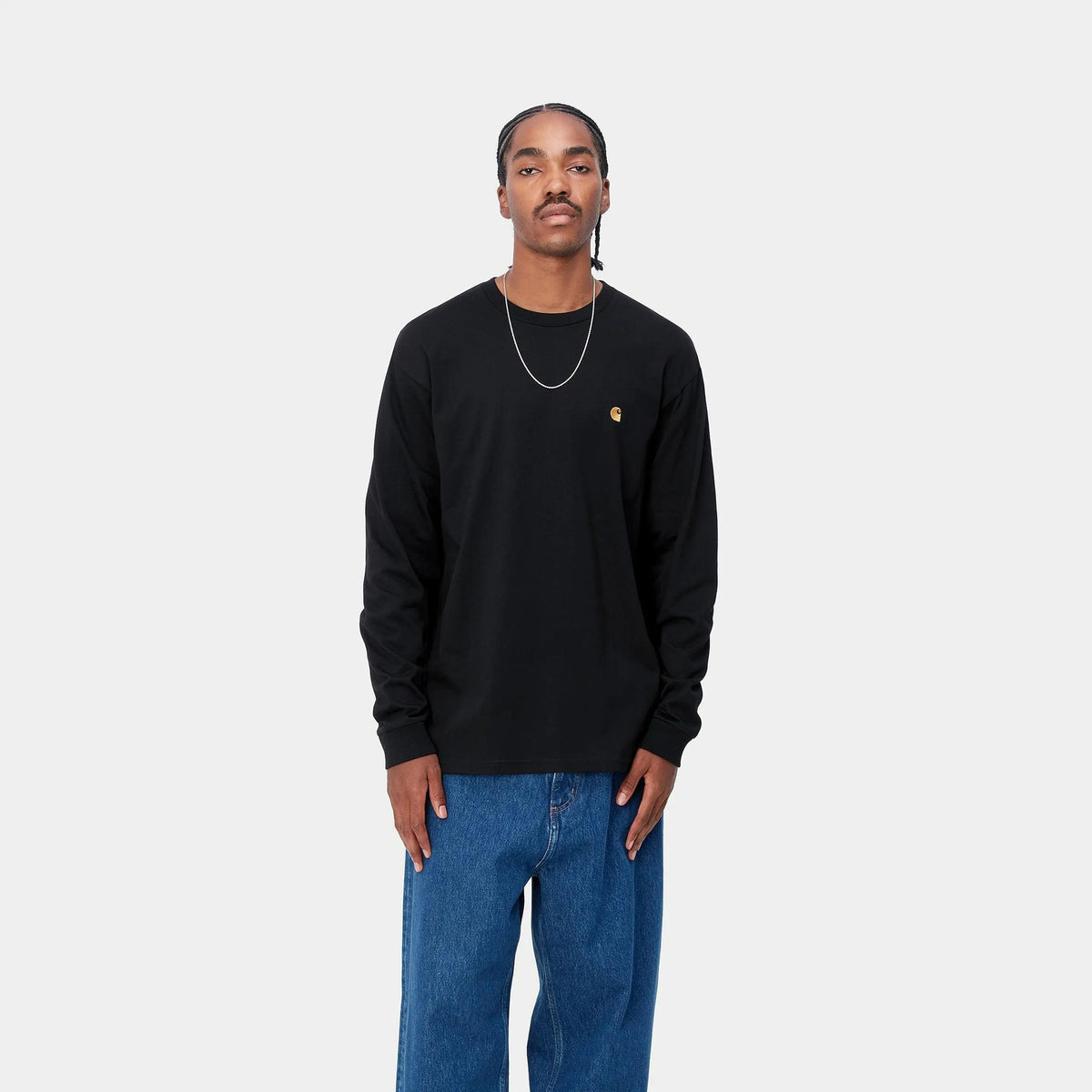 T-shirt manches longues Chase noir Carhartt WIP porté de face avec un jean bleu large, coupe ample