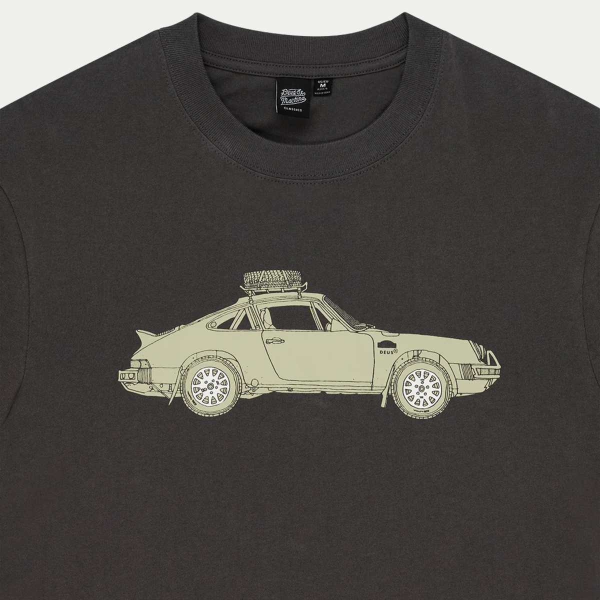 Détail de l’encolure du T-shirt Park anthracite : étiquette Deus Classics et haut de l’illustration Porsche 911 safari