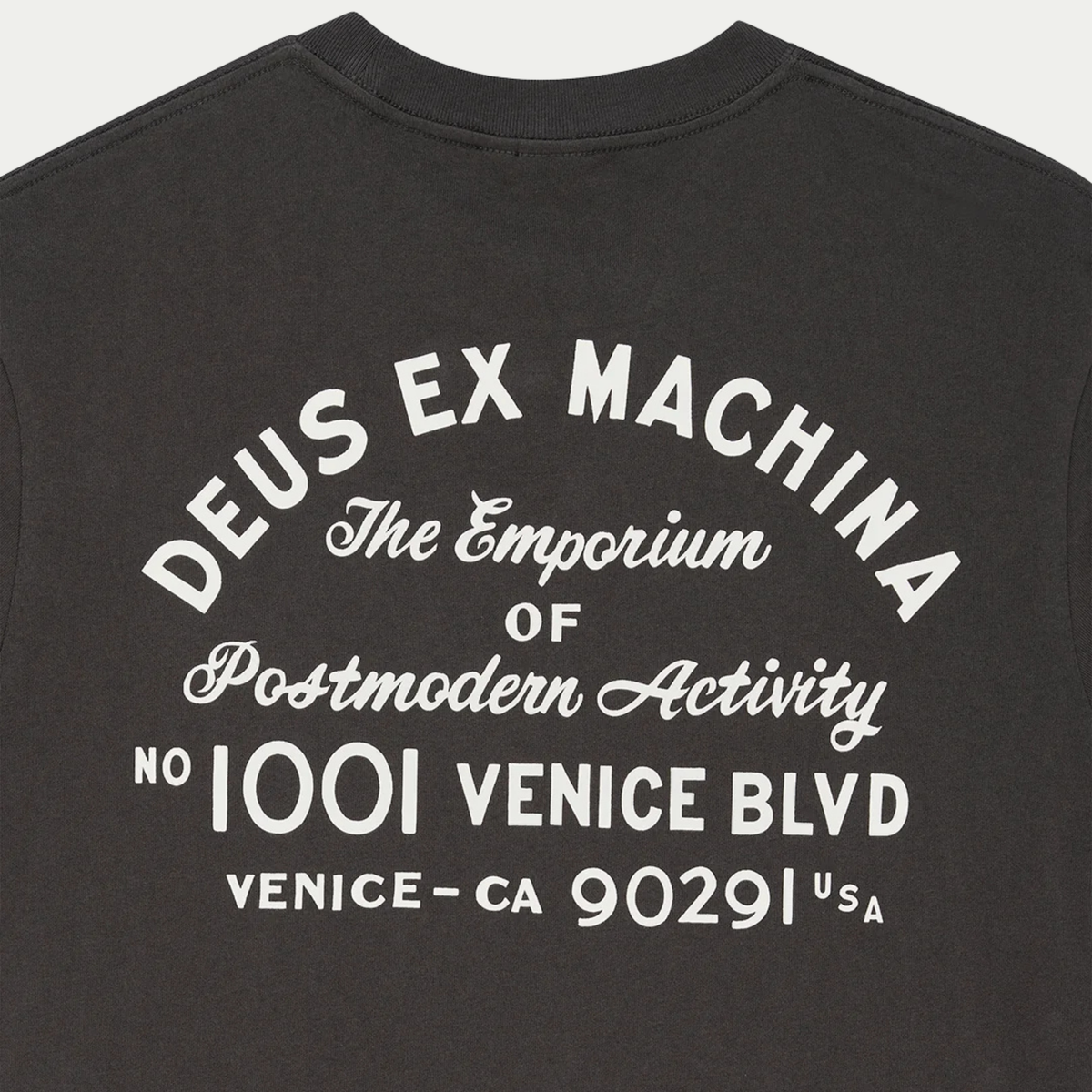 Gros plan du dos du T-shirt Park anthracite : lettrage arqué Deus Ex Machina et adresse Venice imprimés en blanc cassé
