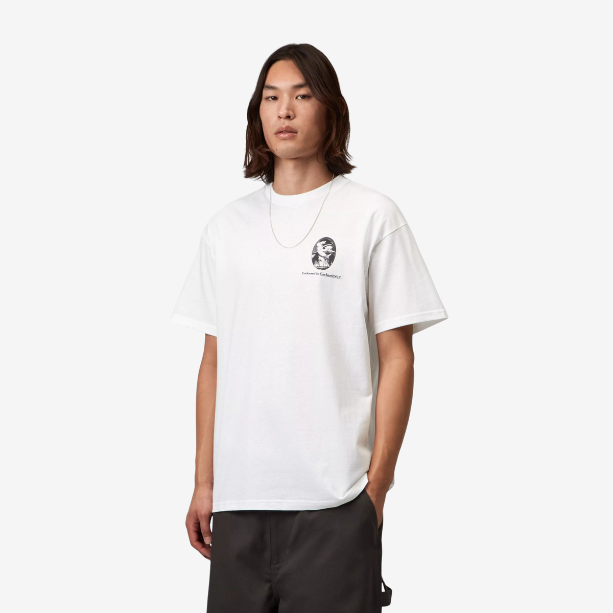 T-shirt Vote Carhartt WIP blanc porté de trois quarts, coupe loose et médaillon imprimé sur la poitrine