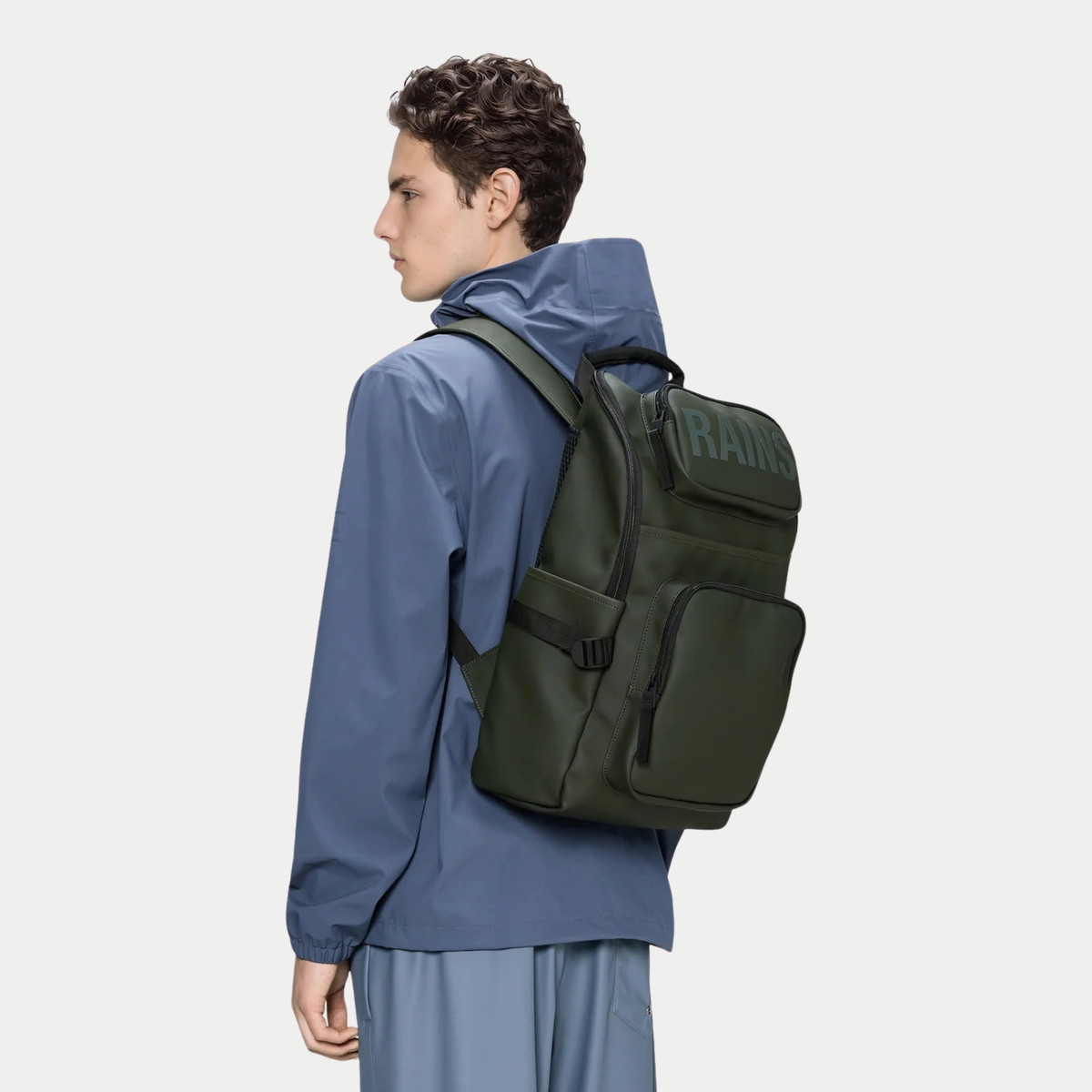 Texel Cargo Backpack vert kaki Rains porté sur le dos, silhouette rectangulaire et poche latérale à sangle
