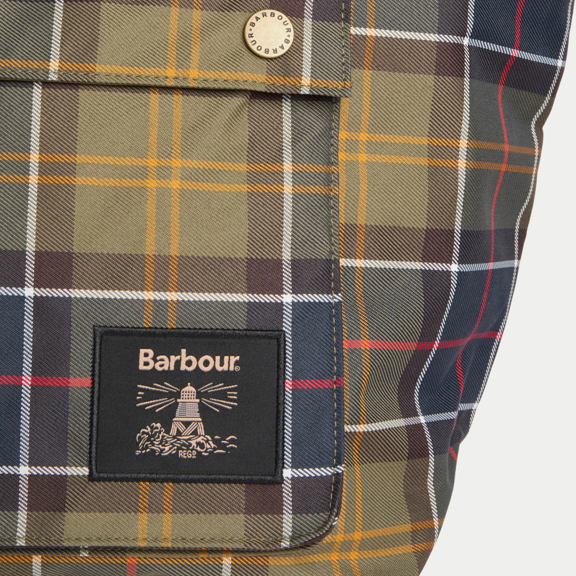 Détail du tissu tartan olive du Tote Bag Barbour : bouton-pression gravé et patch logo phare