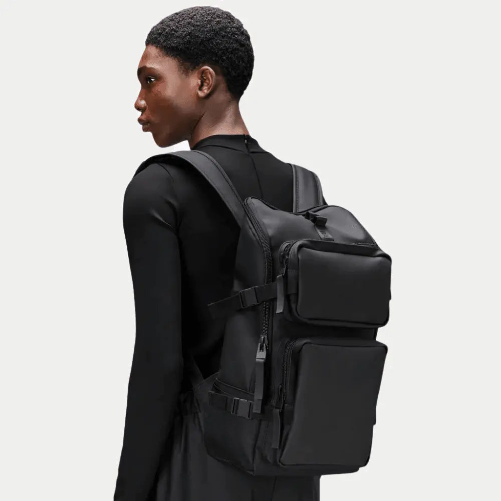 Trail Cargo Backpack noir porté, silhouette haute et boucles latérales noires