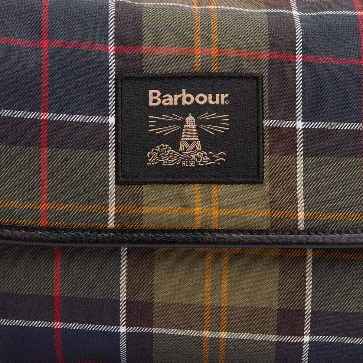 Badge Barbour au phare sur le rabat de la trousse suspendue, entre tartan olive et passepoil similicuir