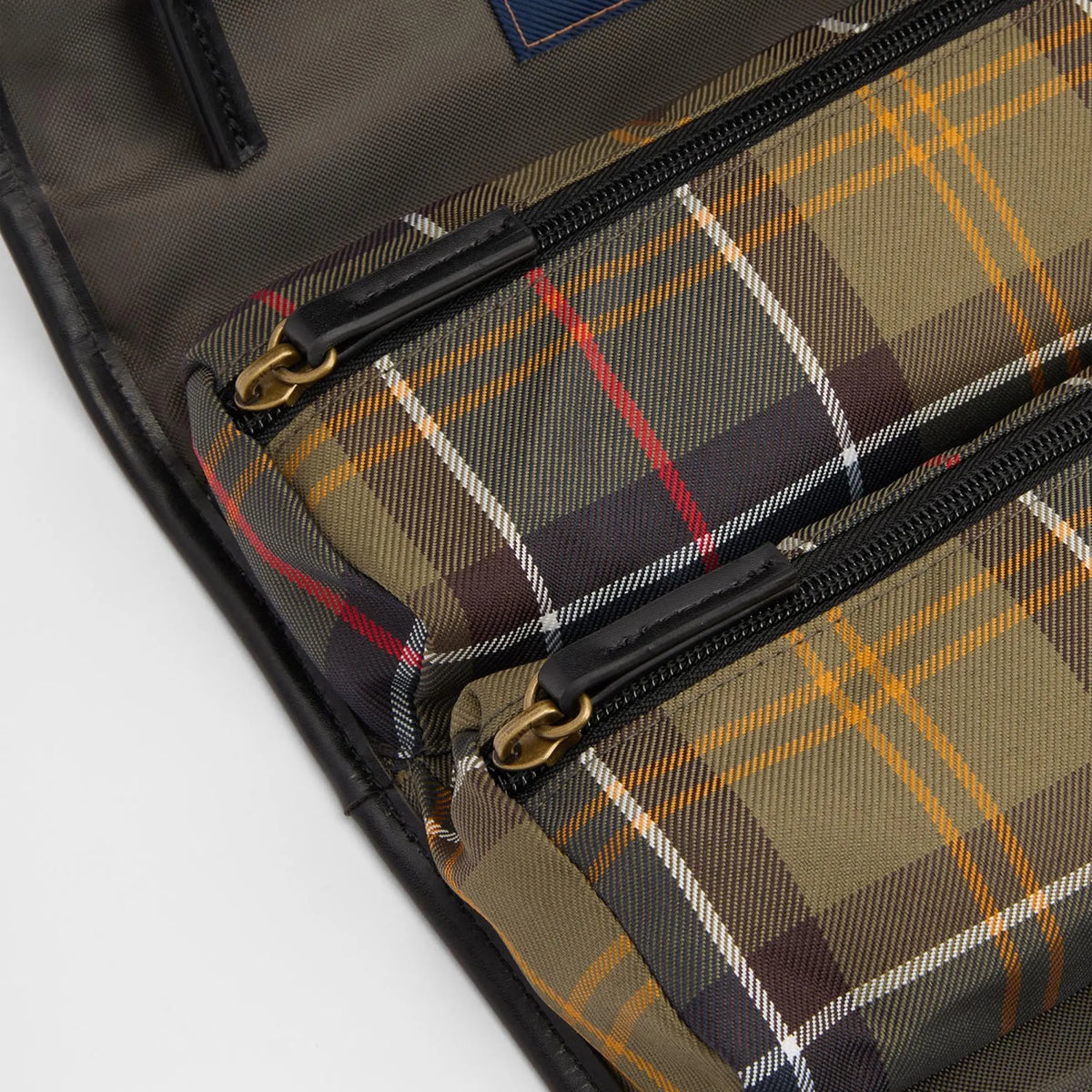 Intérieur déplié de la trousse suspendue : deux poches zippées tartan, tirettes cuir et anneaux laiton
