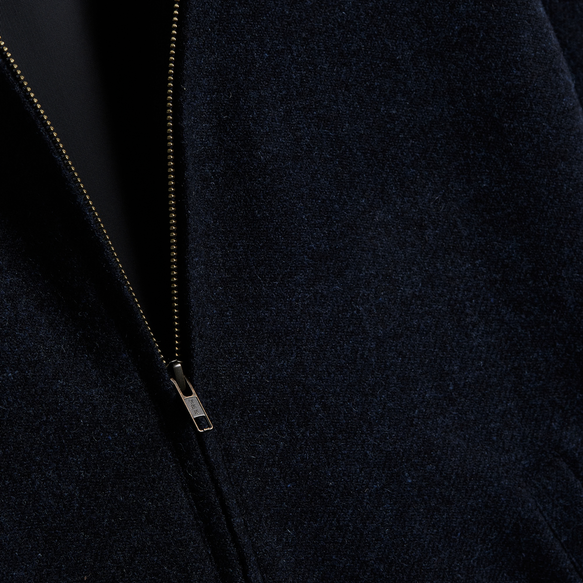 Fermeture zippée YKK entrouverte sur la doublure de la veste Aurelia bleu marine