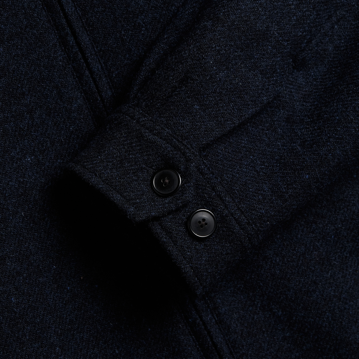 Poignet de la veste Aurelia bleu marine fermé par deux boutons foncés