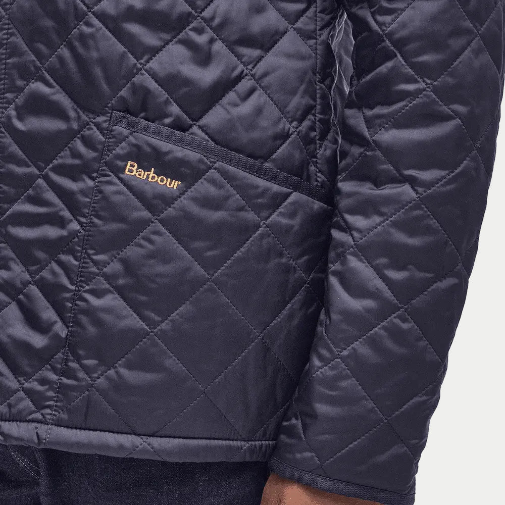 Détail de la poche passepoilée et du logo Barbour brodé sur la veste matelassée Liddesdale bleu marine