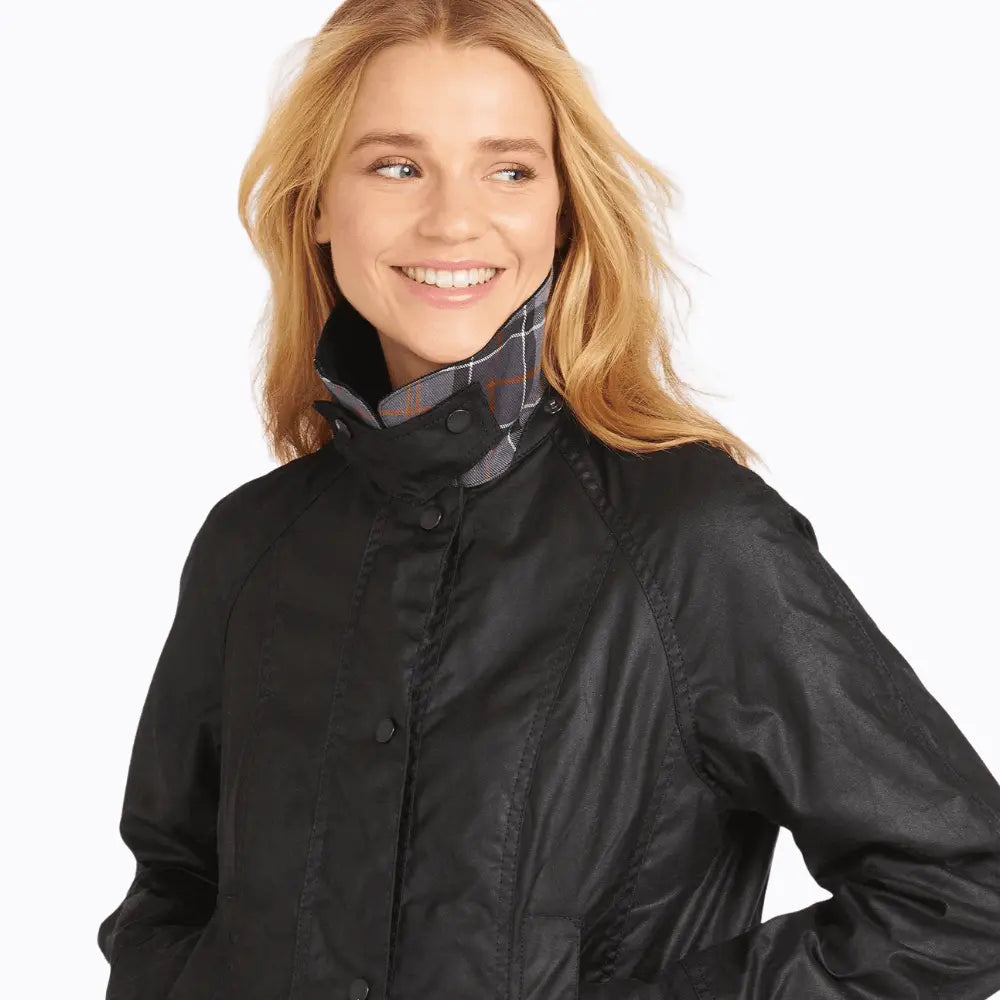 Col montant de la Beadnell noire fermé par pression, tartan gris et orange à l'intérieur