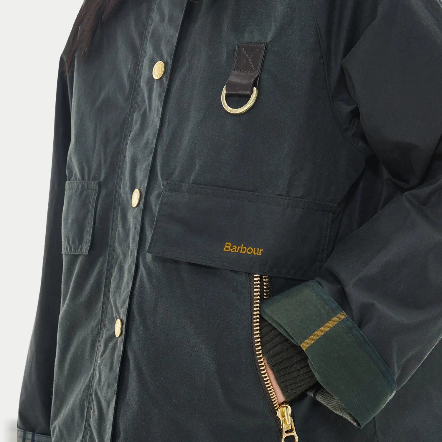 Veste Catton sage Barbour - gros plan sur l'anneau en D, la poche à rabat et la doublure tartan au poignet