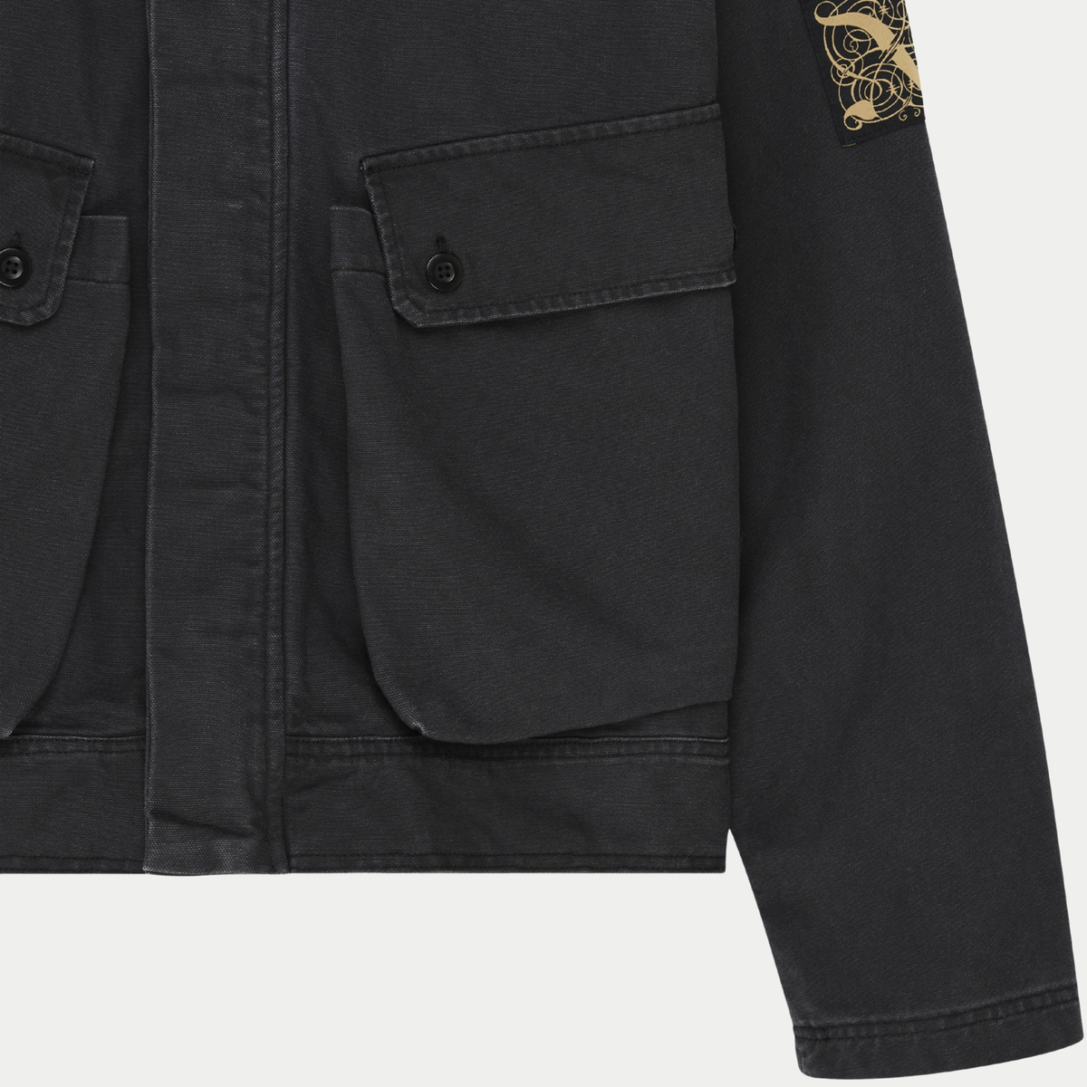 Veste Common State Anthracite Deus Ex Machina - détail de la poche à rabat boutonnée et de l'écusson brodé doré