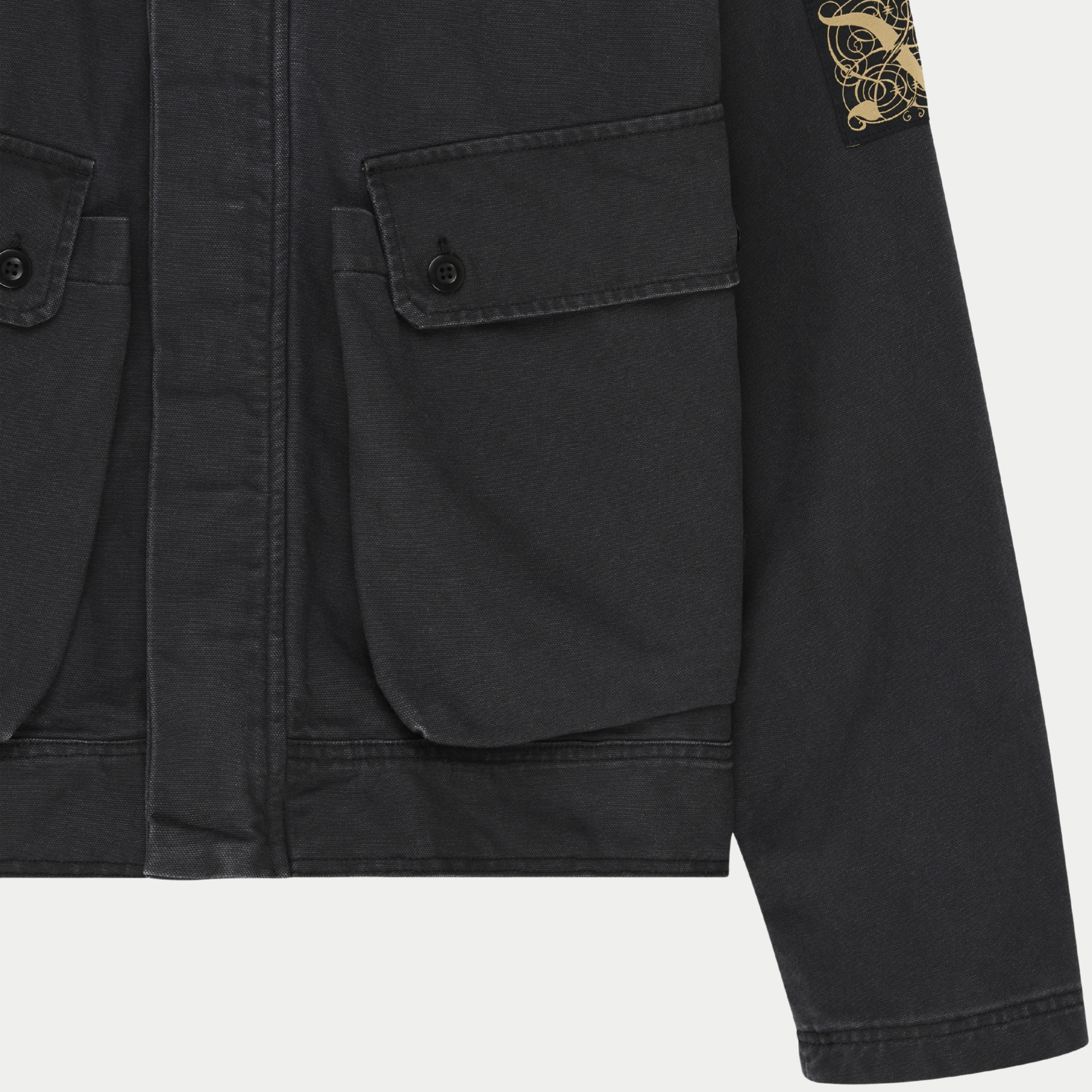 Veste Common State Anthracite Deus Ex Machina - détail de la poche à rabat boutonnée et de l'écusson brodé doré