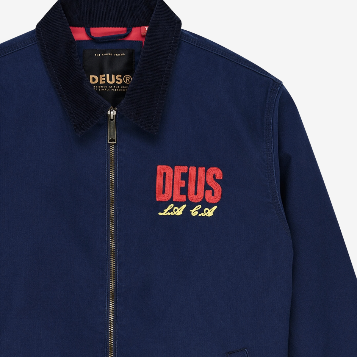 Détail de la Veste Cutaway Bleu Marine Deus Ex Machina : col velours côtelé, intérieur de col rouge, broderie chaînette poitrine