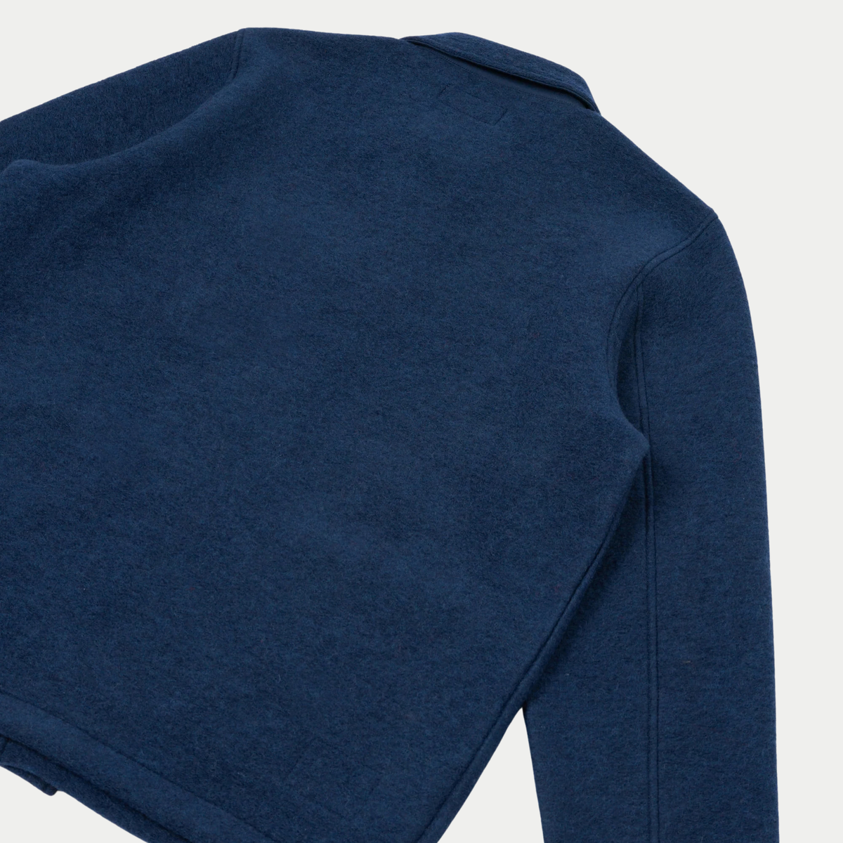 Dos à plat de la veste Field indigo, haut du col et couture d'épaule surpiquée
