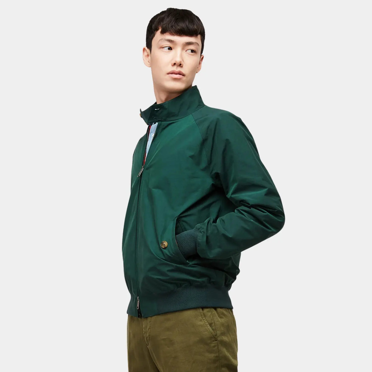 G9 Racing Green portée de profil, main dans la poche latérale, col monté et bas côtelé vert foncé