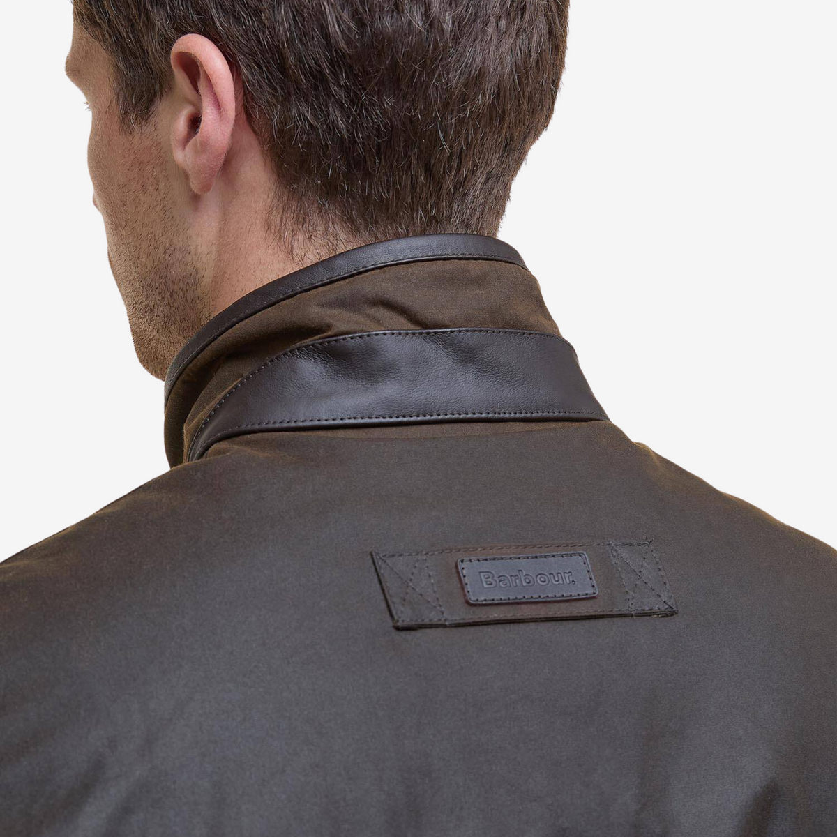 Nuque de la veste Hereford Olive Barbour : col bordé de cuir et patte cousue portant un badge Barbour embossé