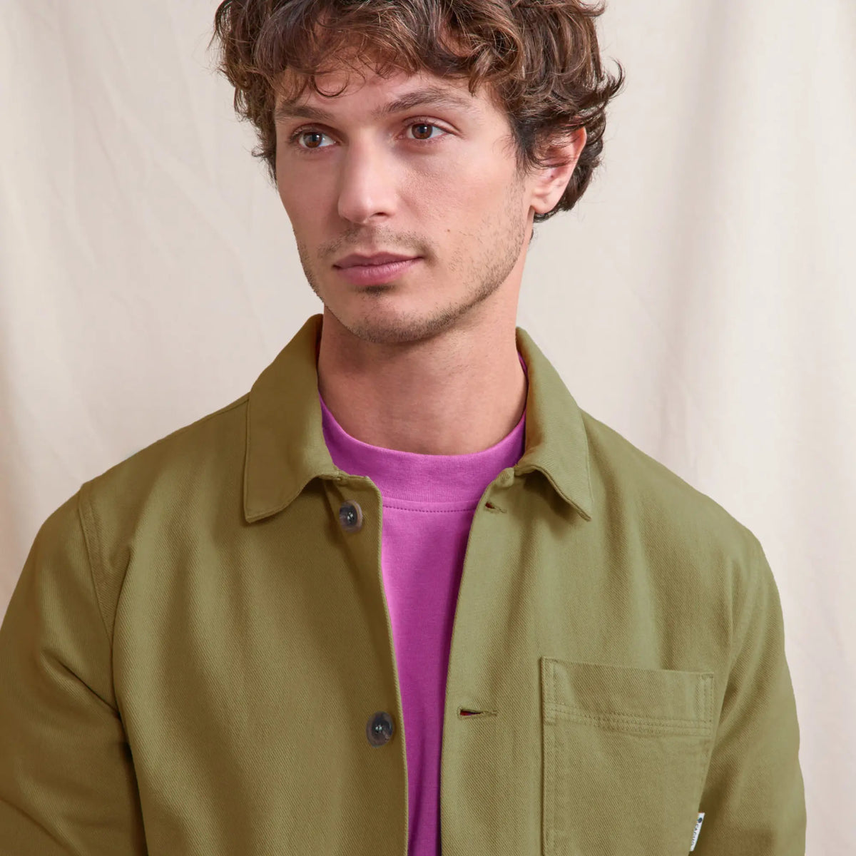 Gros plan du col et du boutonnage de la veste Lorge kaki sur un t-shirt fuchsia