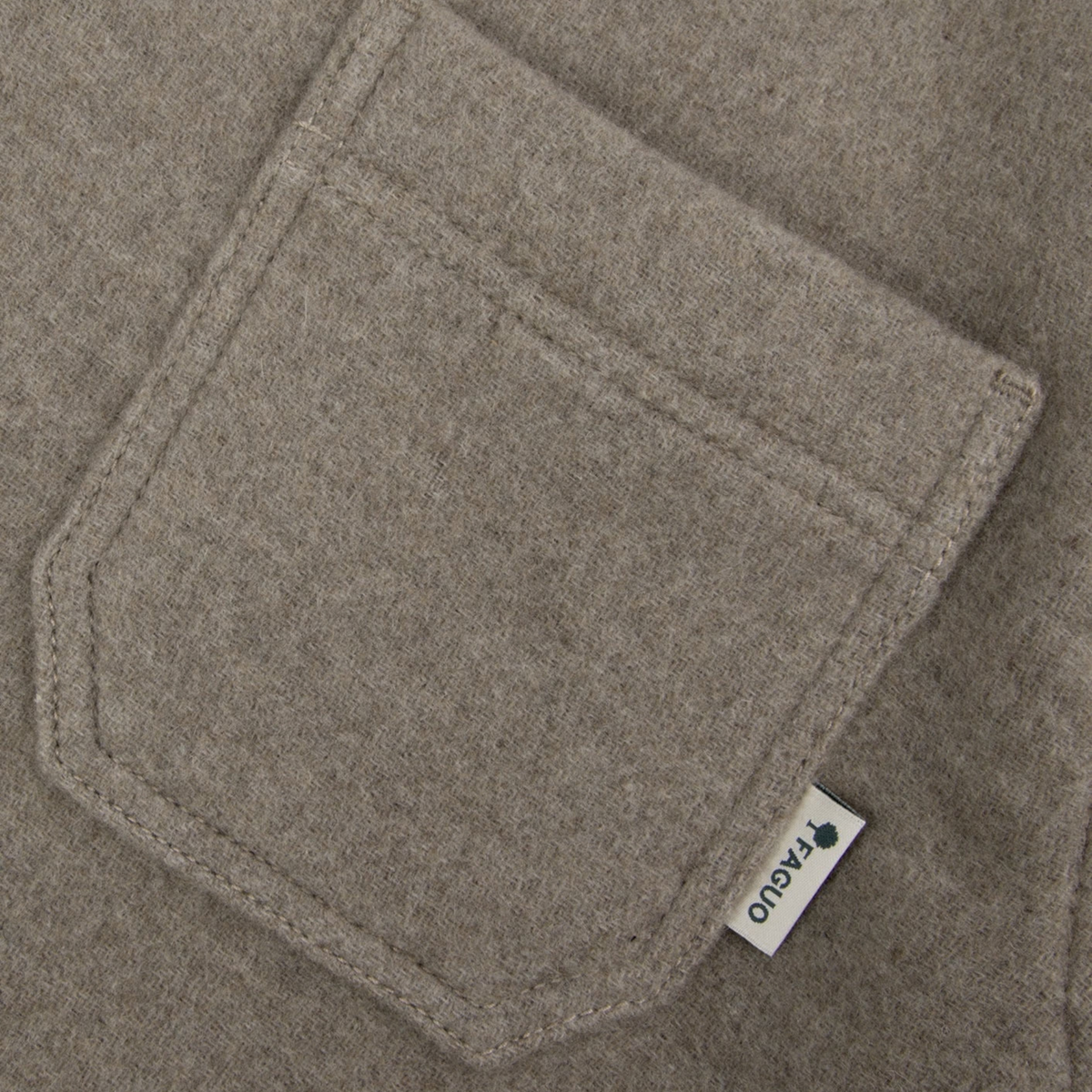 Détail du lainage beige chiné et de la poche plaquée à étiquette tissée Faguo