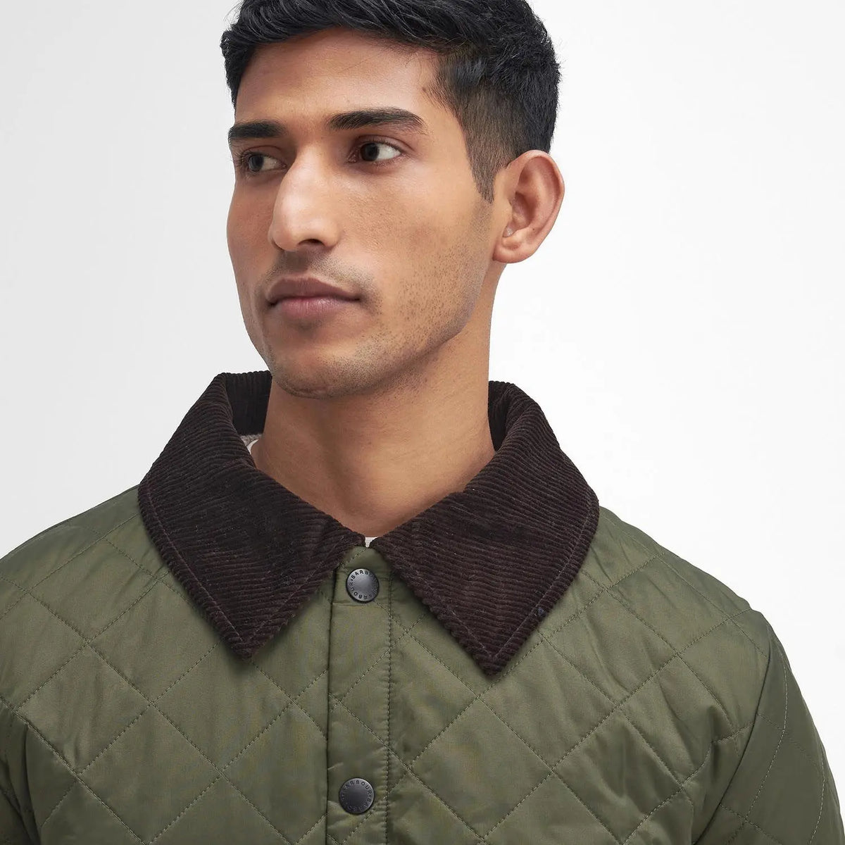 Détail du col en velours côtelé brun aubergine de la veste Liddesdale olive Barbour et de sa pression gravée