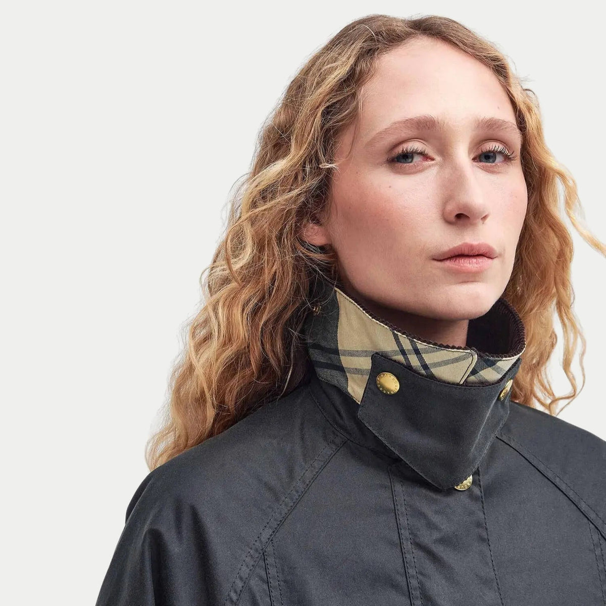 Col relevé de la Veste cirée Barbour Modern Beadnell Sage sur une écharpe tartan