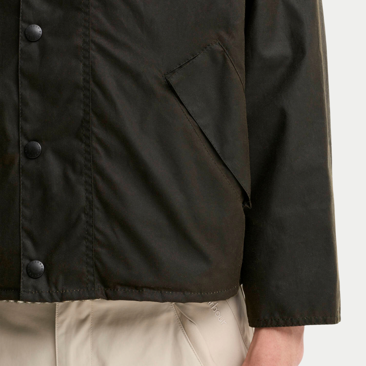 Détail de la poche basse en biais et de la patte boutonnée de la veste OS Transport Olive Barbour