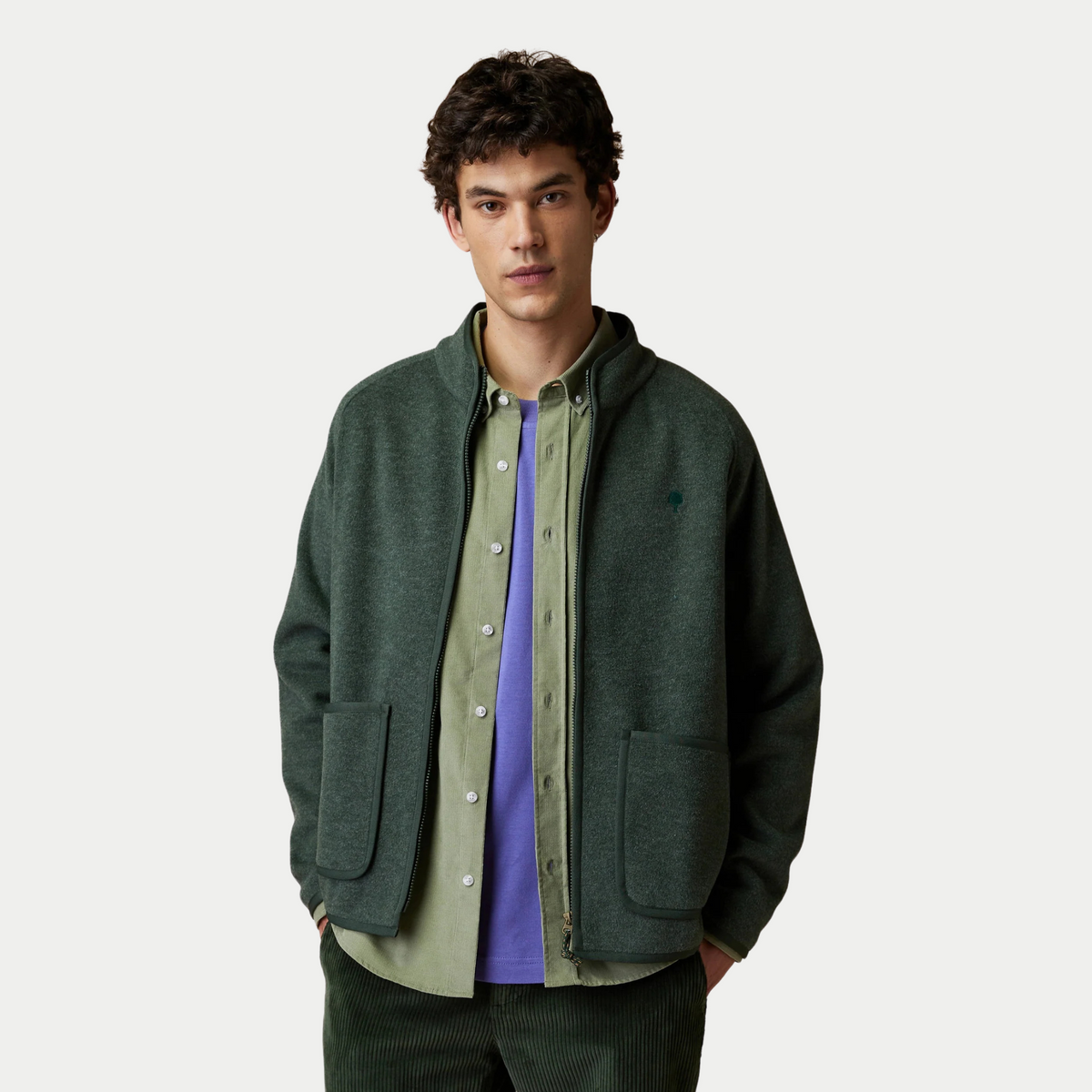 Veste polaire Faguo Chinon vert foncé portée ouverte sur une chemise en velours vert clair