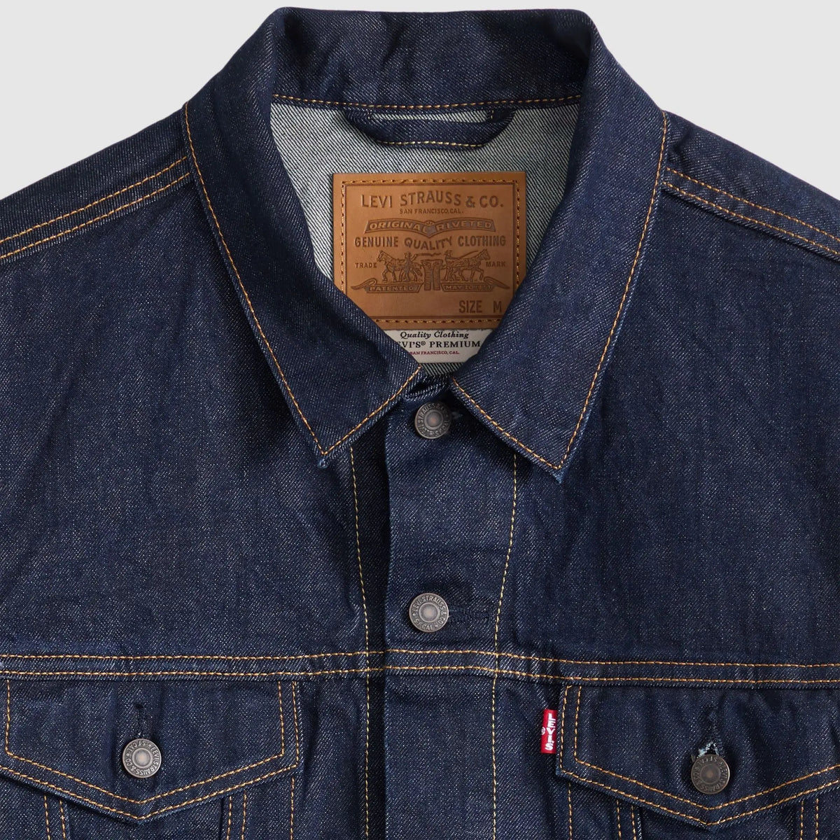 Détail du col de la veste Trucker Levi's Wash It Out Rinsed : patch cuir Levi Strauss, boutons métal, surpiqûres orange