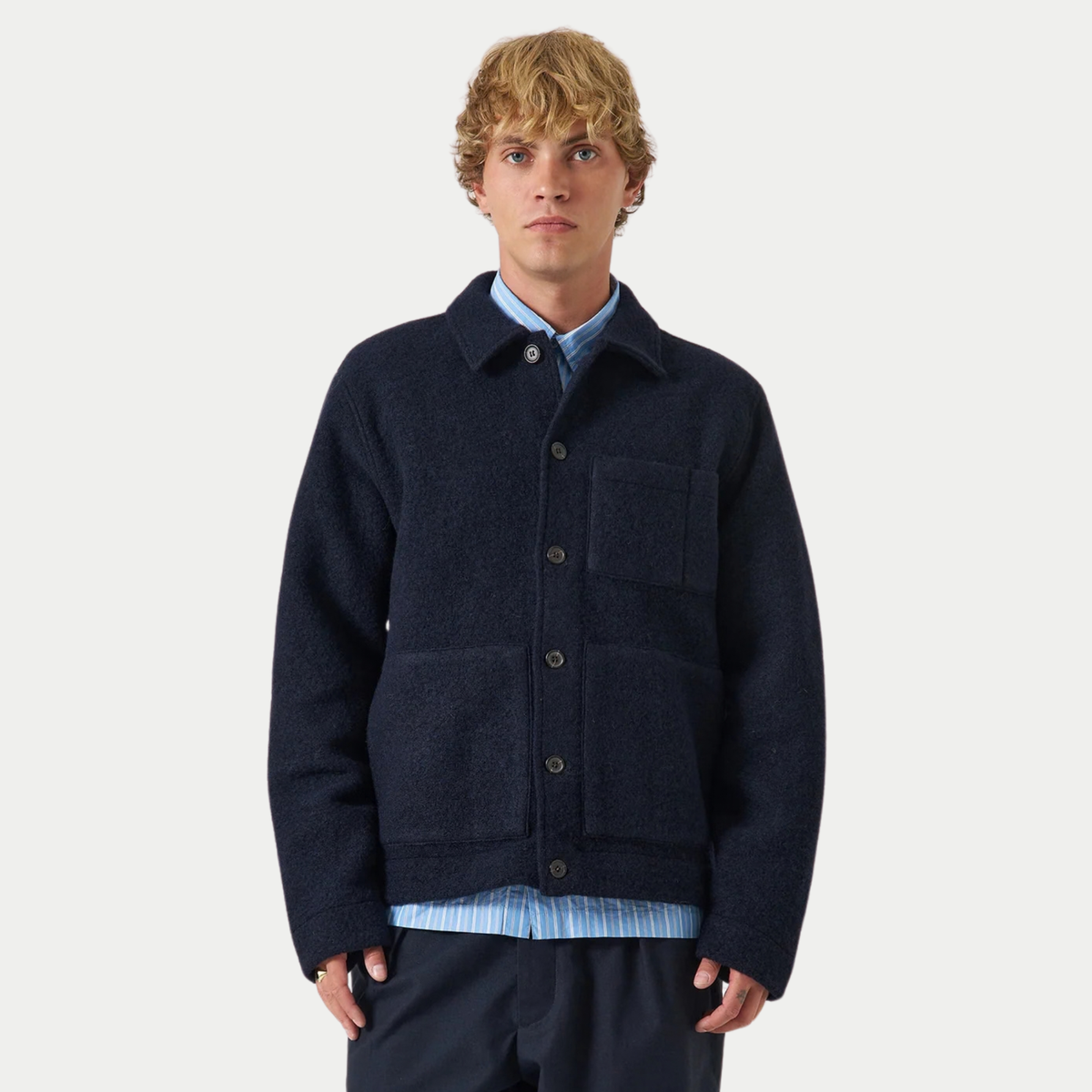 Veste Uniform bleu marine portée boutonnée sur une chemise rayée, vue de face