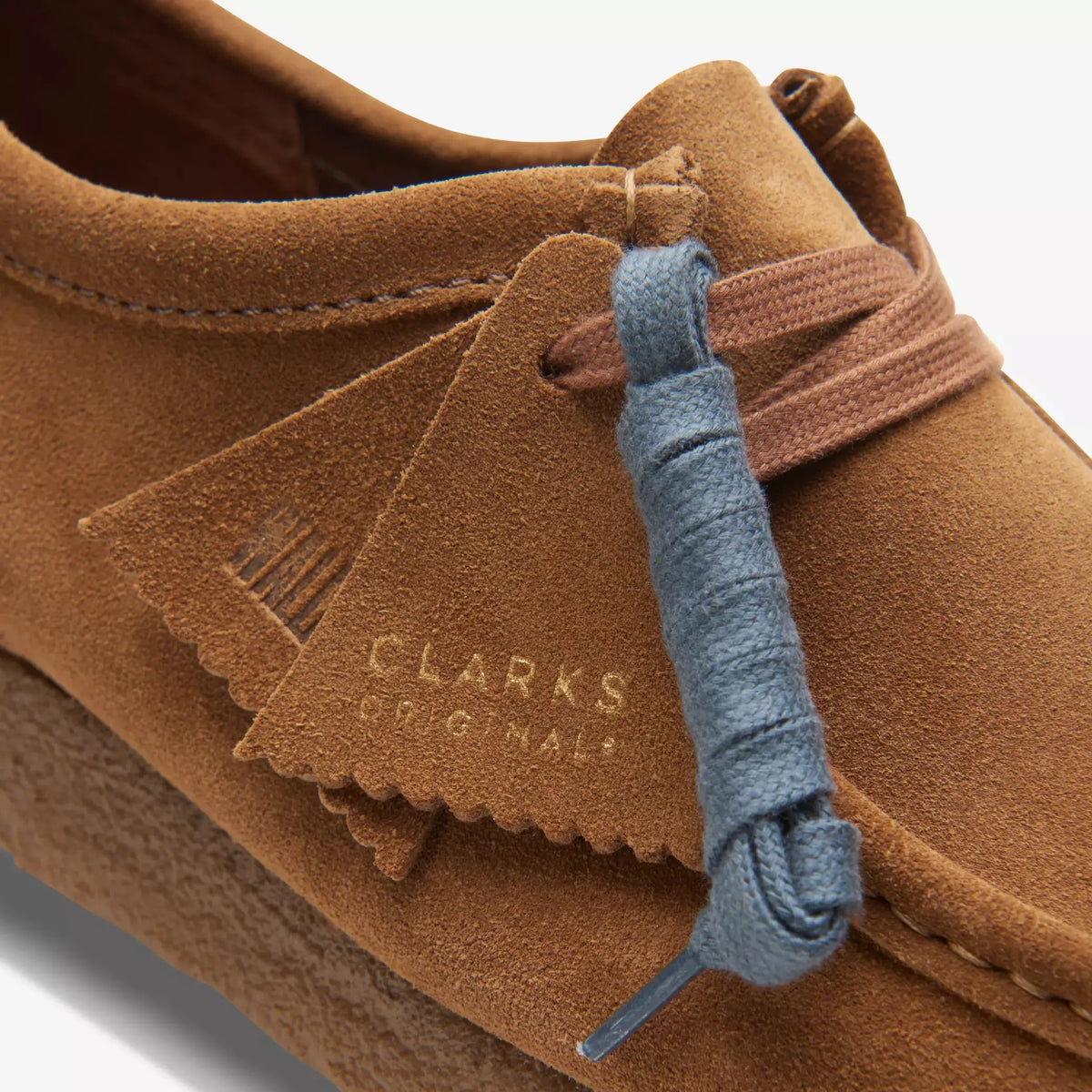 Gros plan de la languette frangée Wallabee Cola et du lacet Bleu Marine fourni