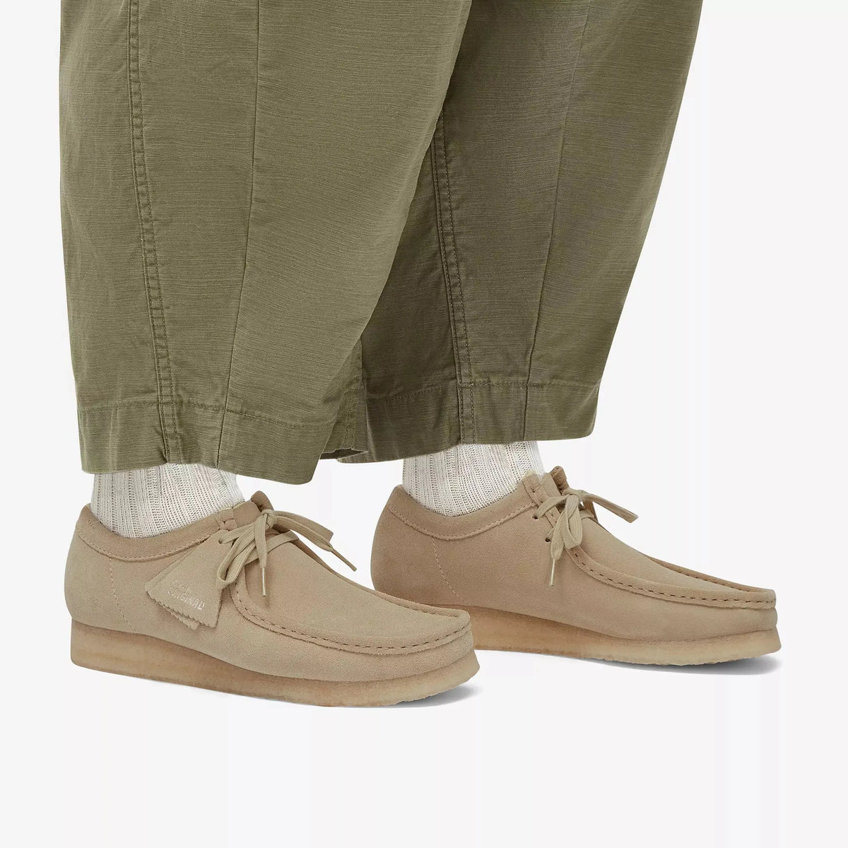 Wallabee Maple portées au ras du sol avec un pantalon kaki et des chaussettes blanches